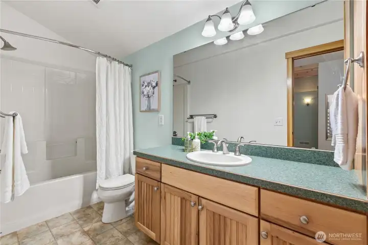 The full ensuite bath upstairs offers a functional layout with oversized vanity, ample storage, and a tub/shower combination designed for everyday convenience. The full ensuite bath upstairs offers a functional layout with oversized vanity, ample storage, and a tub/shower combination designed for everyday convenience.