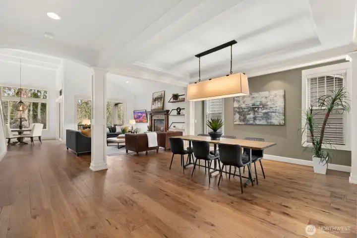 Expansive main living area combines elegant formal dining with a bright great room, showcasing wide-plank hardwood floors, Craftsman millwork, and abundant natural light.