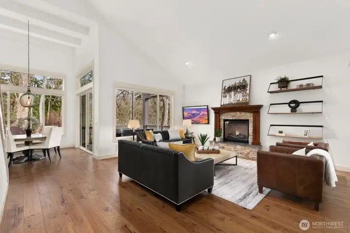Vaulted ceilings, oversized windows, and a stunning stone fireplace anchor this light-filled great room overlooking the peaceful Pacific Northwest landscape.