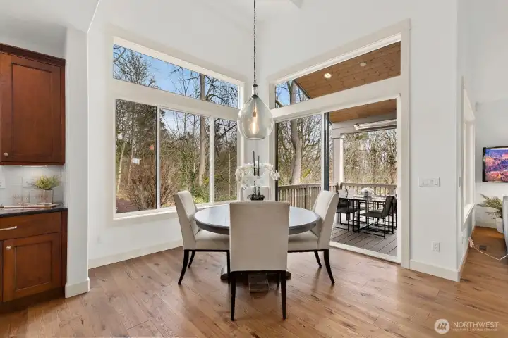 Sunny breakfast nook surrounded by large windows offers peaceful views of the private backyard and direct access to the covered outdoor entertaining deck.