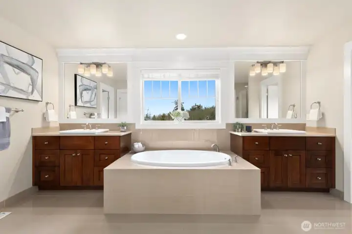 Spa-inspired primary bathroom includes dual vanities, oversized soaking tub, expansive mirrors, abundant storage, and elegant finishes throughout.