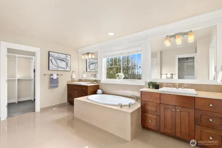 Elegant owner's ensuite combines dual vanities, spa-style soaking tub, generous storage, and timeless finishes designed for everyday comfort and relaxation.