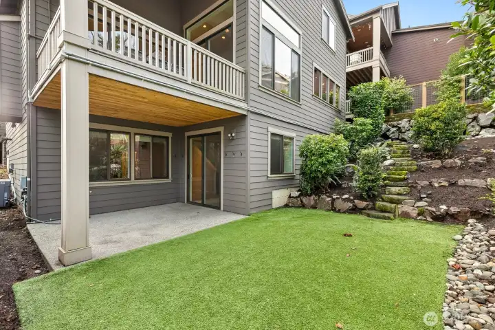Rear elevation showcases multiple covered outdoor living spaces, professionally landscaped grounds, and seamless indoor-outdoor living.