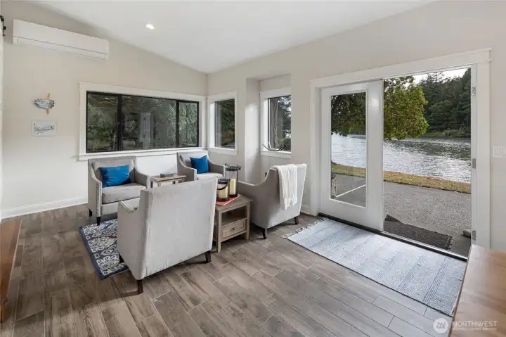 Large windows frame peaceful Mitchell Bay water views, bringing natural beauty indoors while creating a relaxing space to gather.