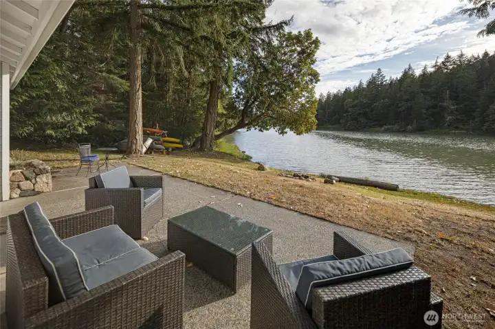 Patio overlooks the shoreline and mature trees, providing a private outdoor space just steps from the water.