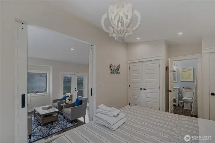 Spacious bedroom offers direct access to the living area through sliding barn doors, creating a flexible and functional floor plan.