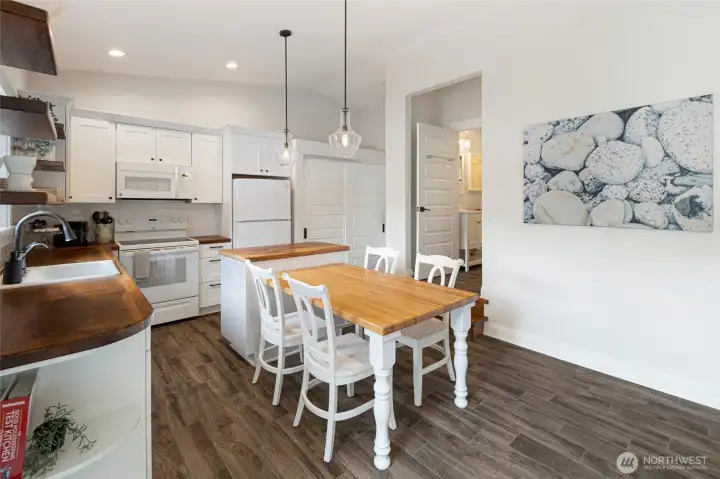 Updated kitchen combines modern finishes with efficient design, featuring butcher block countertops, open shelving, and abundant storage.