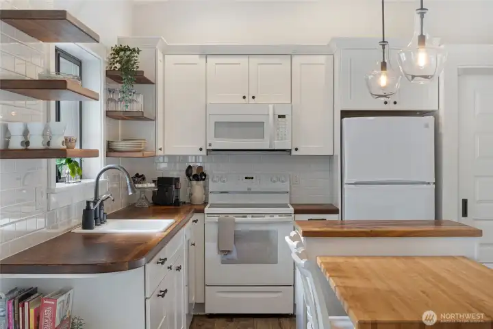 Functional kitchen offers quality cabinetry, subway tile backsplash, and an island workspace ideal for everyday meal preparation.