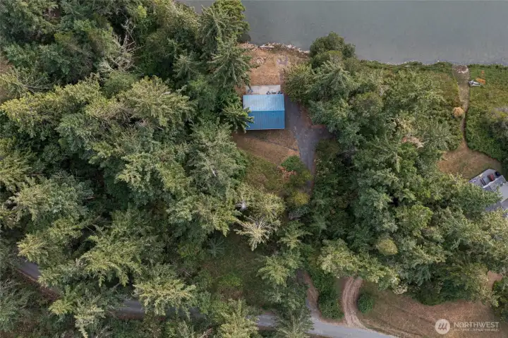 Bird's-eye view showcasing the waterfront cabin, private shoreline, mature trees, and secluded setting nestled along the bay.