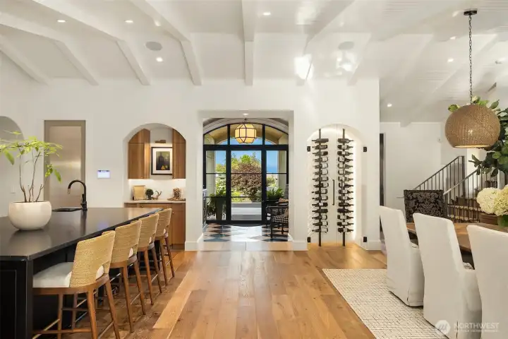 In addition to wine storage, there ia a dry bar with built-in Thermador dual-zone wine fridge.  Arched architecture is quietly repeated throughout.  The laundry room sits behind a soft-close pocket door with reeded glass for privacy.