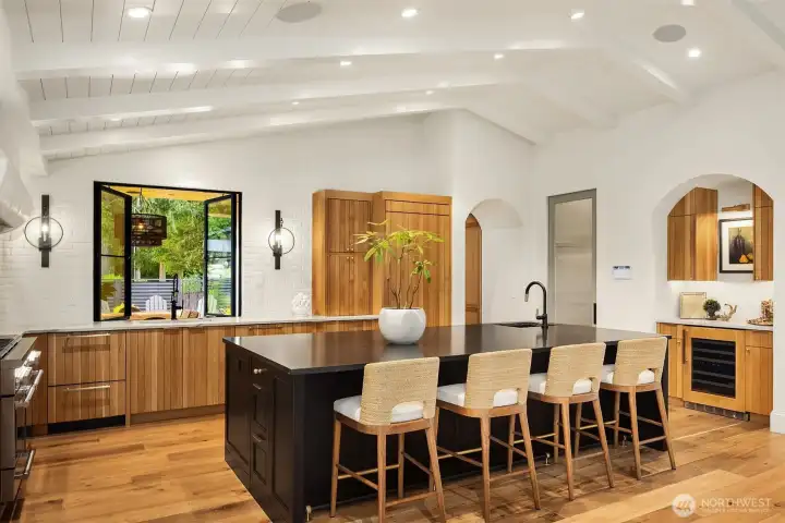 Kitchen features custom cabinetry, appliance garage, and brick walls create European vibe.  Kitchen features a seated island with additional under counter storage on three sides.
