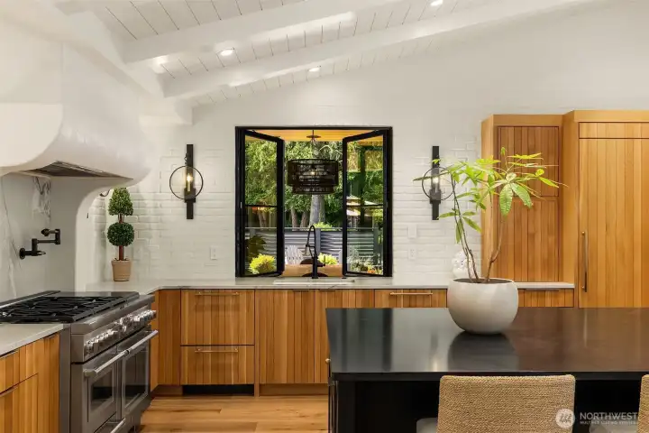 Kitchen also features a pot filler, Venetian plaster vent hood, Thermador two-drawer refrigeration unit is built into the island.  Shaw kitchen sink with touchless Brizo faucet.  Pass-thru french casement window for seamless entertaining.