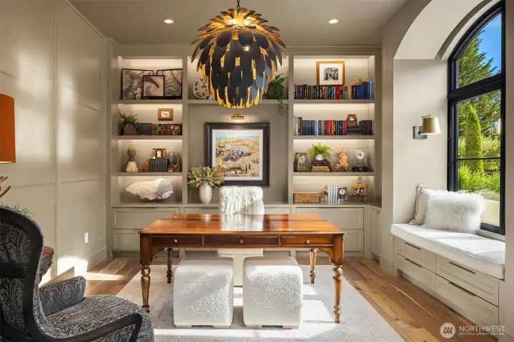 Study with custom cabinetry, designer lighting, window seat with arched window.  French casement windows with hidden retractable screens and electric shade that recesses into the ceiling.
