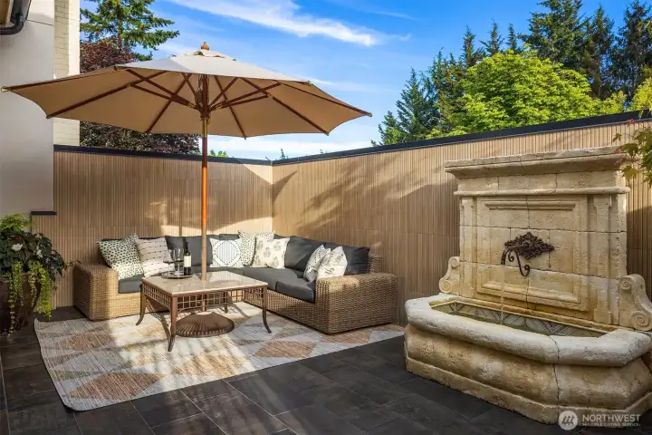 Private courtyard off the the primary bedroom with fountain.  Features tiled walls and floor, French doors and custom gate.
