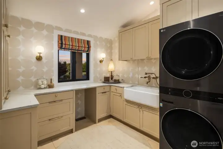 Laundry room features cement wall tiles, travertine floors with radiant heat, Shaw sink with Phylrich wall faucet and hand-held sprayer.  Also features a built in drop zone with bench seating and hooks for hanging.
