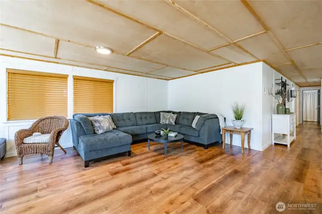Newer laminate flooring, wood paneled ceiling.