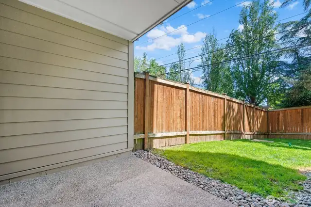 Patio is adjacent to community yard and provides direct access to unit through glass paneled door