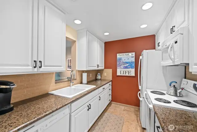 Kitchen with designer cabinets, tile backsplash and floor, dishwasher