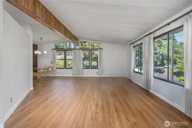 As you enter, the large living room w/ vaulted ceilings welcomes you in. Notice the huge windows to keep it bright thru out the seasons.