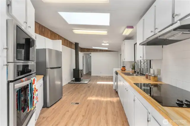 Looking thru the kitchen into the bonus area. The slider to the back deck is on the right.