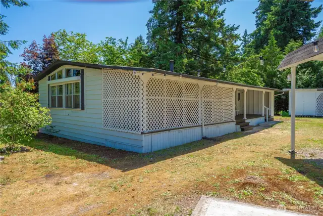 Looking at the back of the home toward the enclosed privacy space and covered back deck.
