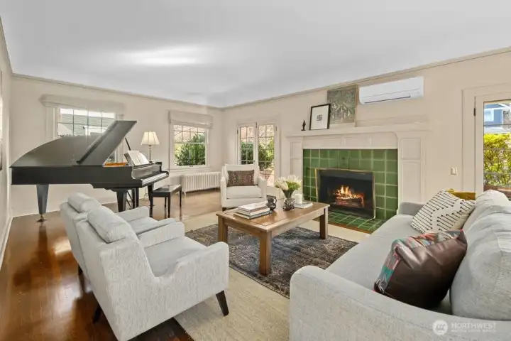 The living room is flooded with natural light from three sides. Note the french doors leading out to the private, covered front porch.