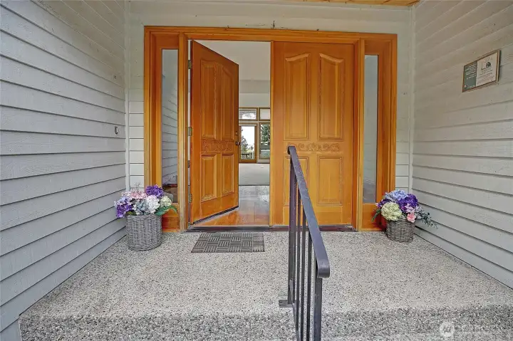 Double door entry...with covered porch. Through the door to light and airy great room/living room whatever  you want to call it.  Easy access to the den/office to the right side, to the primary bedroom to the left.