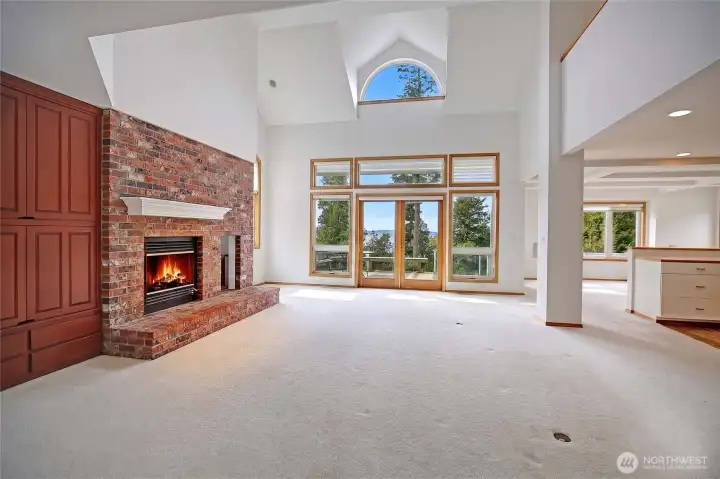 Spacious great room/living room with brick fireplace near kitchen...hey picture the sound and trees, ceiling fan.