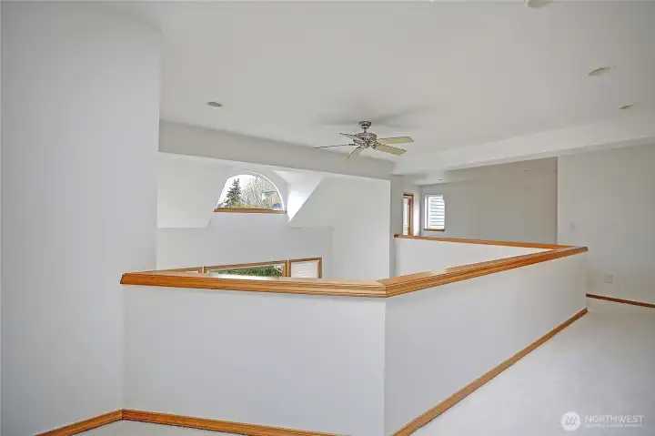 Upper level hallway to loft area overlooks the downstairs entrance and great room, ceiling fan.