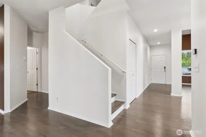 View of entry from the eat-in kitchen area. As you enter the home, you will love the SOARING 2-story ceilings in the formal living room, leads into your formal dining room. Coat closet in the hall, then stairs up. Powder room is to your left in this picture.