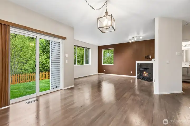 Family room view from your kitchen, large windows grace this home throughout, massive patio doors also let in all the light, gas fireplace to keep you cozy on cooler days and nights. I love that the powder room shown on your right is off of living space. Garage is down that hallway as well.