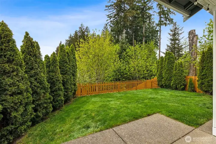 View of your backyard from the patio, small fencing separating the level portion with the terraced gardens.