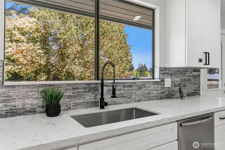 Look out to the huge backyard from the kitchen sink. Look out to the huge backyard from the kitchen sink.