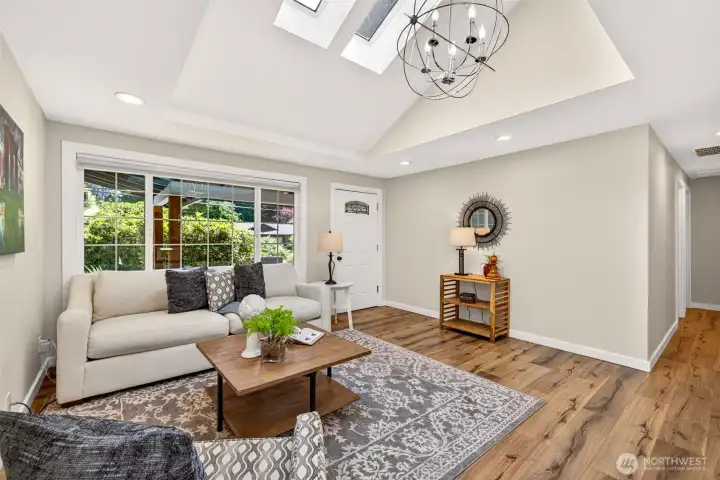 Soaring ceilings and a generous wall of glass keep this living space open and sunlit, with a hallway leading privately to the bedrooms for a smart separation of living and resting areas.