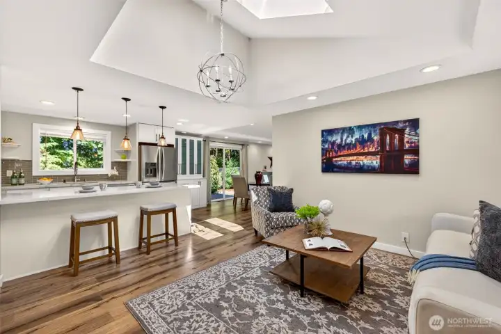 An open layout connects the living room to the updated kitchen and a dining space beside the backyard slider, with the peninsula offering casual seating so the cook stays part of the conversation.