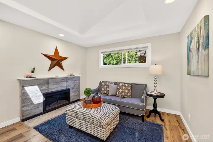 A tile-surround fireplace anchors this comfortable living space, offering a quiet spot to unwind that stays bright with natural light from above.