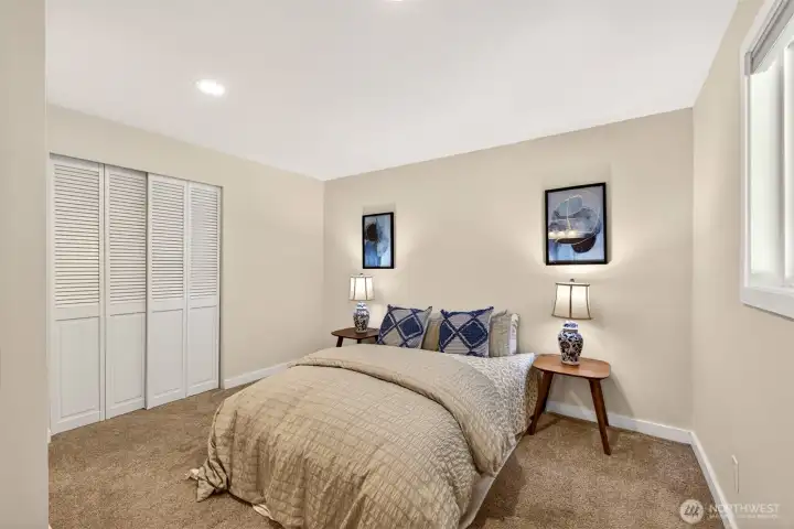 A comfortable bedroom with a wide closet and soft natural light offers a restful retreat or a flexible space for a home office or guest room.
