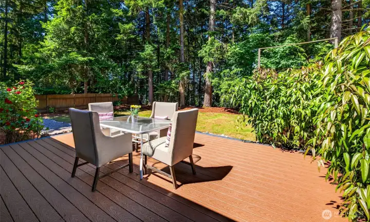 Surrounded by blooming roses and towering firs, the deck offers a tranquil setting for morning coffee or evening gatherings in complete privacy.