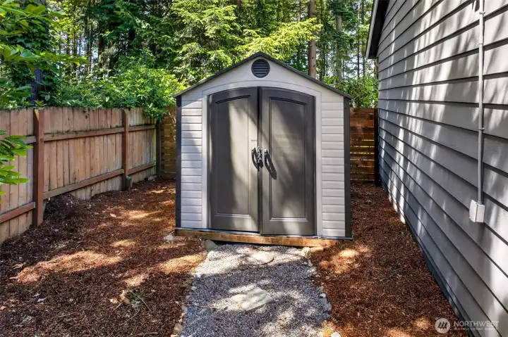 A dedicated storage shed tucked along the side yard adds valuable space for tools, bikes, and seasonal gear, helping keep the garage and home clutter-free.
