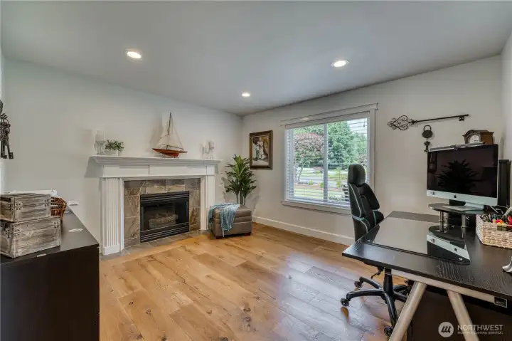 Home office or sitting room with engineered hardwood flooring and gas fireplace.