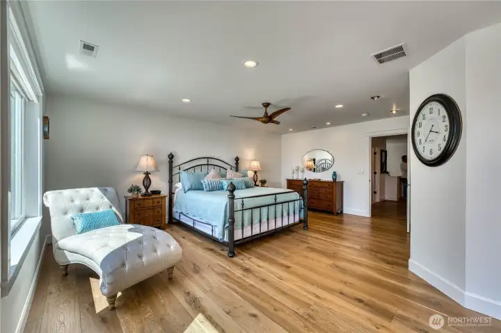 The primary bedroom is spacious and bright, with ceiling fan, electric fireplace and it's own private deck for relaxing whiile enjoying the views.