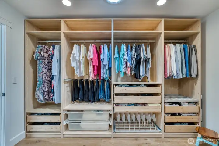 Extrodinary walk in closet with custom built ins.