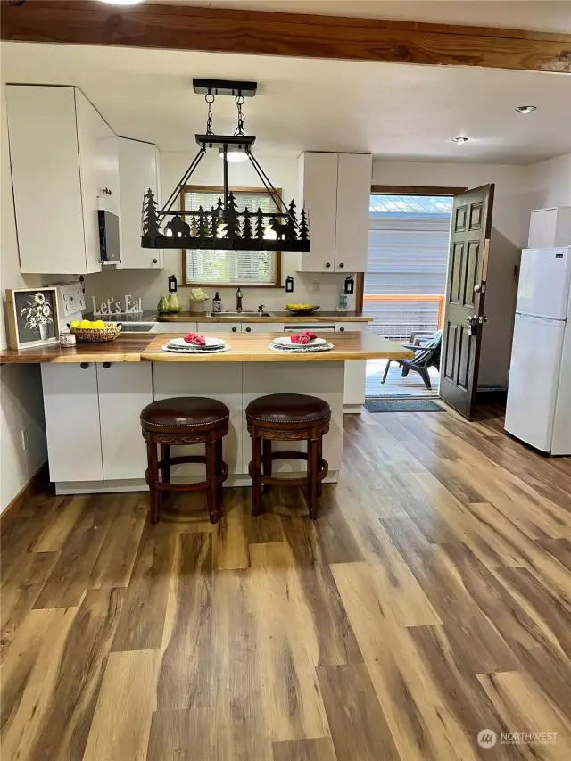 Open Dining~Kitchen with lots of natural light with wood accents.