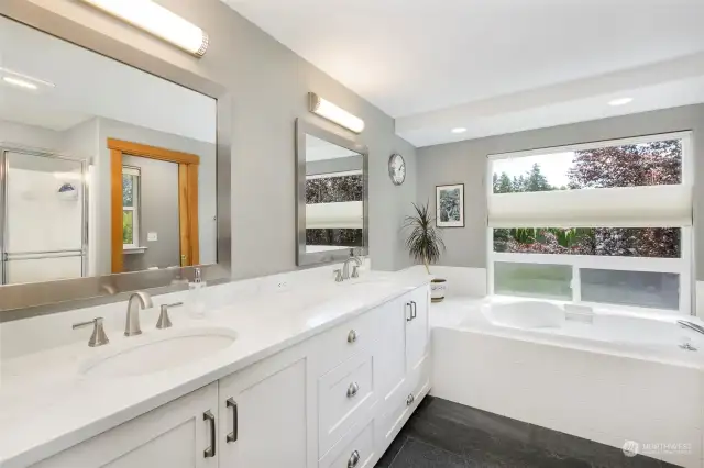 Bright &spacious primary bath, 2 sinks, soaking tub w/ custom window & blinds above it; tile floors, separate shower & toilet room w/ window