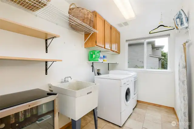 Bright & large laundry room w/ utility sink, tile floor & good storage space