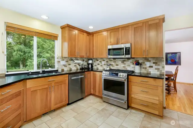 Updated kitchen w/ cherry cabinets, quartz counters & tile flooring. New GE Cafe gas range/oven.