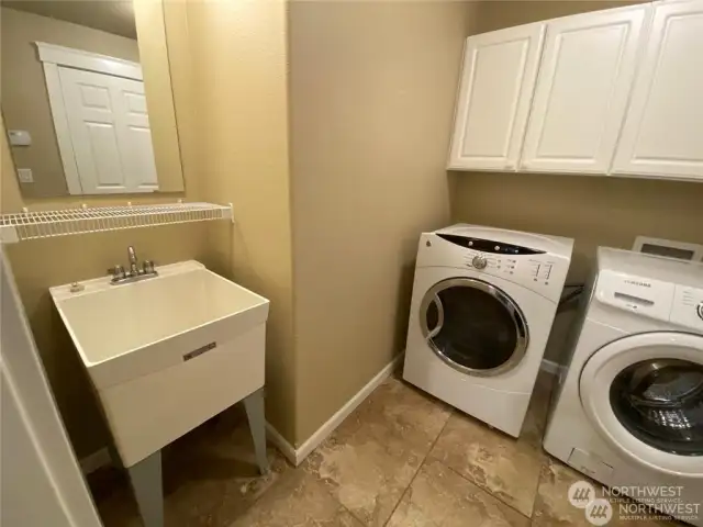 15907 - The laundry room connecting the garage to the foyer is complete with a utility sink.