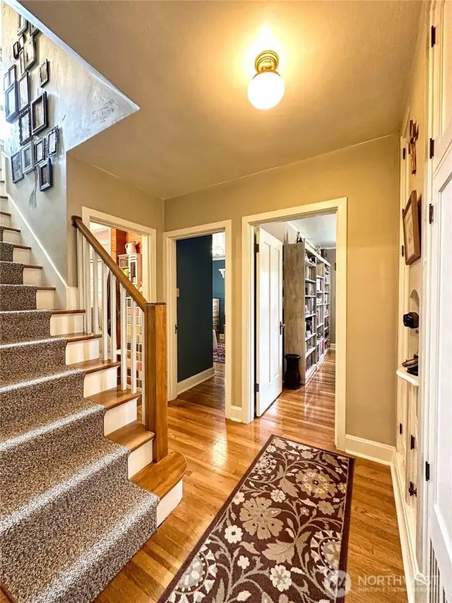 Graceful hallway nook serves as a central hub connecting the main level bedrooms and bathroom to upper-level bedroom and bathroom