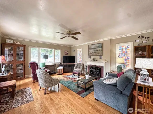 Bright and inviting living room featuring rich hardwood floors and a cozy fireplace, perfect for relaxing or entertaining
