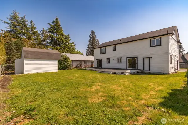 Back yard with outbuildings for garden tools. Lot is 8,855 SQ FT, it is level and partially fenced.